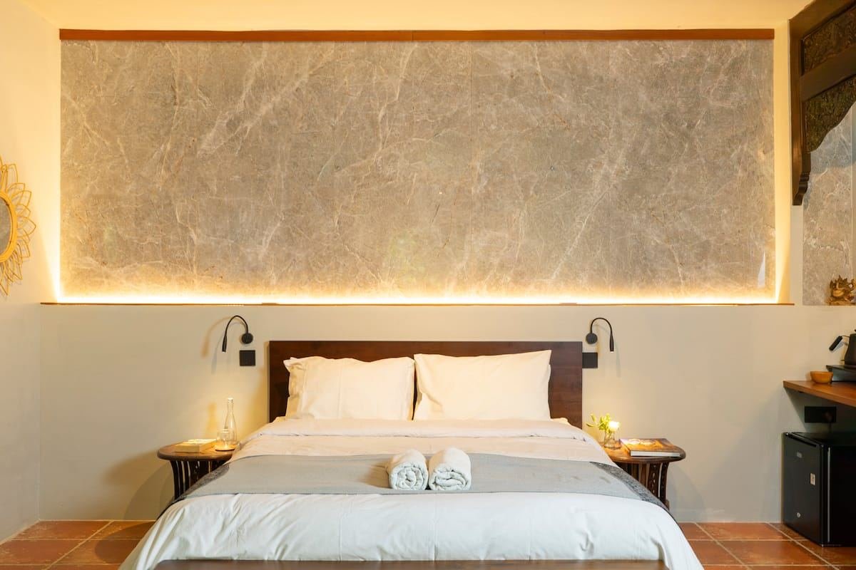 Bed with reading lights and a lit stone panel