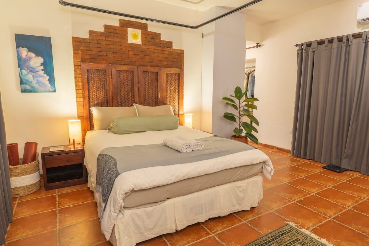 The bedroom with a carved wooden headboard