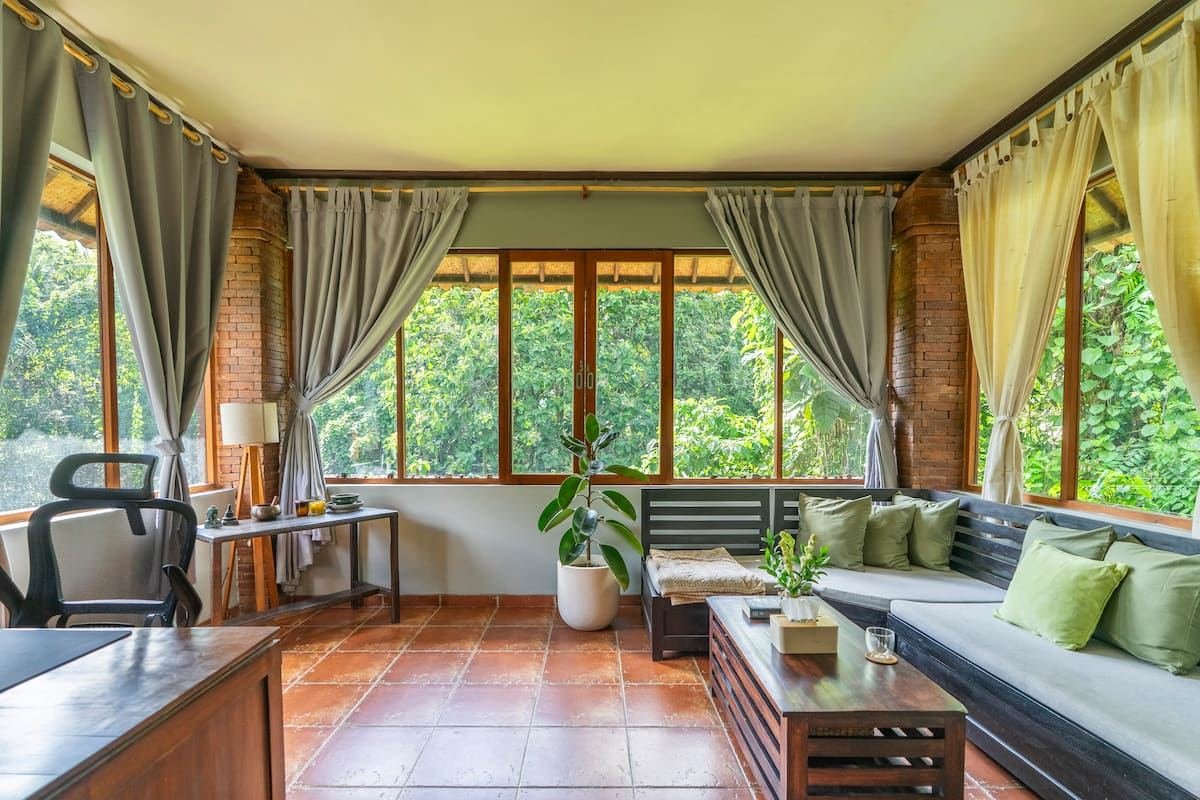 The upstairs living room, with windows onto the jungle on three sides